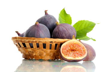 Ripe sweet figs with leaves in basket isolated on white