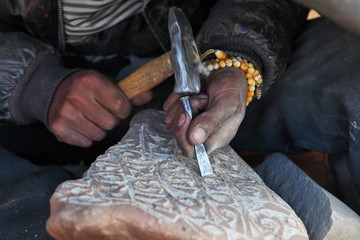 Making Tibetan Buddhist Mani Stone - stone with holy mantras 