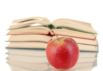 stack of open books with apple on white background close-up