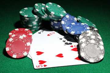 Cards and chips for poker on green table
