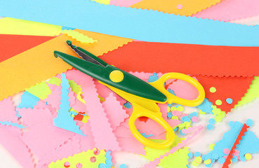 Colorful zigzag scissors on color paper background