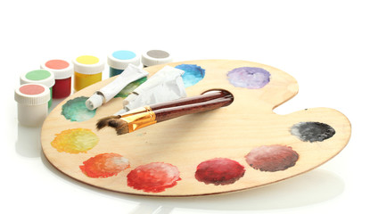 wooden art palette with paint and brushes isolated on white