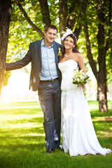 Happy bride and groom in a greenl summer park