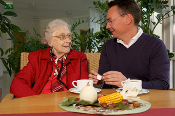 Seniorin mit Enkel beim Kaffee trinken
