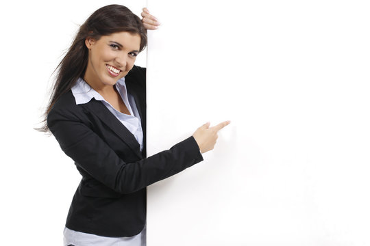 Junge h&uuml;bsche Frau zeigt auf leeres Plakat