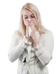 Blond young woman blows her nose - isolated