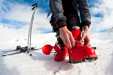 Afwasbaar fotobehang getting ready for skiing - fastening the boots © mdurinik