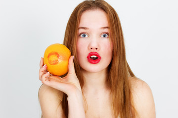 Portrait of young beautiful woman with red grapefruit