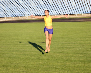 Beautiful teenage sport girl running on the stadium