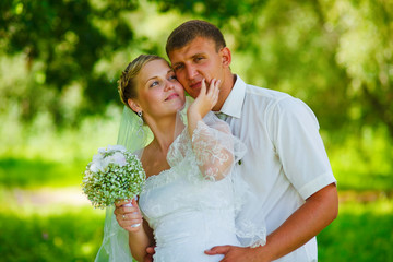 bride groom newlyweds standing in a green forest in summer at a