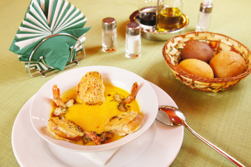 Pumpkin soup with shrimps in a plate