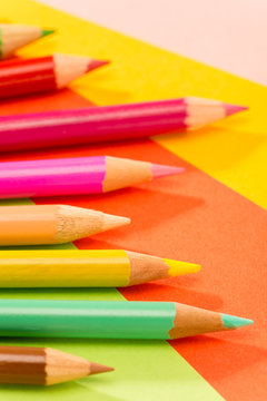Color pencils on colorful papers close-up
