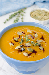 Pumpkin soup with pumpkin oil and seeds close-up