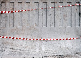 Texture of red and white striped tapes on concrete barrier