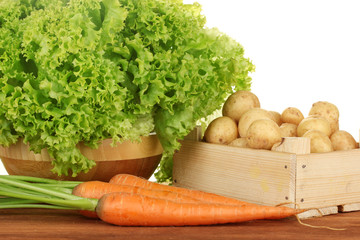 young potatoes in a wooden box with lettuce and carrots