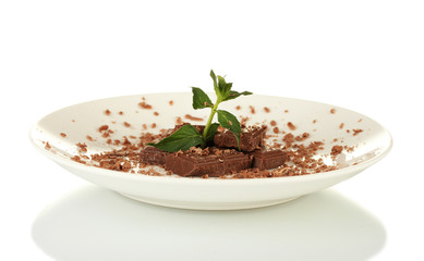 Pieces of chocolate and mint on the plate isolated on white