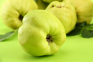 sweet quinces with leaves, on green background