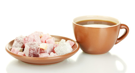 A cup of tea and saucer with delicious turkish delight isolated