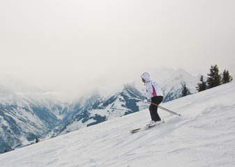 Fototapeta na wymiar A woman is skiing at a ski resort.