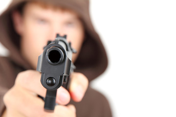 A teenager wearing a hood aiming a gun with white background - 45733527