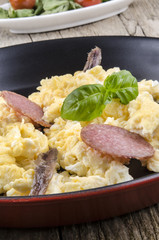 Rührei mit Salami, Sardellen und Basilikum in einer Pfanne