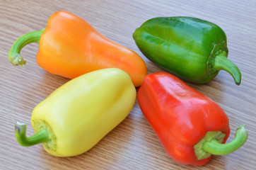 fresh yellow, red, green and orange bell peppers isolated on woo