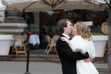 Bride and groom kissing outdoors