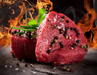 Raw beef steaks with fire flames