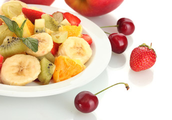 Fresh fruits salad on plate and berries isolated on white