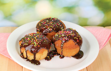 Appetizing cupcakes with chocolate on nature background