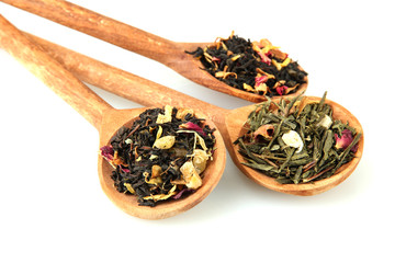 assortment of dry tea in spoons, isolated on white