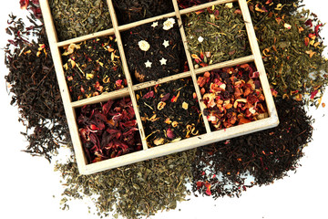 assortment of dry tea in wooden box, isolated on white