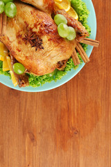 whole roasted chicken with lettuce, grapes, oranges and spices