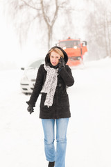 Fototapeta na wymiar Kobieta woła o pomoc złamanym śniegu samochodem