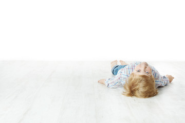 Little boy lying down on floor and looking at camera