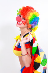 Clown looking to the copy space area in a white studio