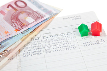 Sparbuch mit Banknoten und Modelhäusern