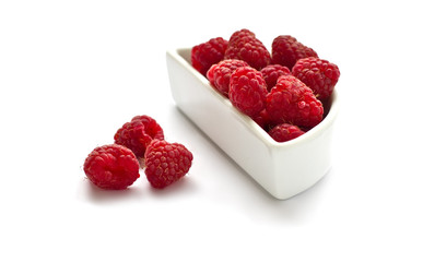 Bunch of fresh raspberries in white dish isolated on white
