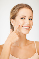 beautiful woman pointing to cheek