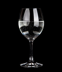glass with water and  flower isolated on black background 