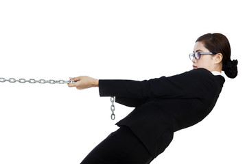 Businesswoman pulling metal chain isolated in white