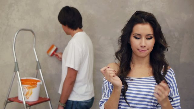 Attractive couple painting wall  together