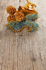 Christmas golden decorations on pine branch on wooden background
