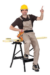 a carpenter pointing up and showing something