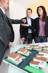 Estate-agent handing keys to new home owners
