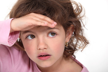 Young girl shielding her eyes from the sunlight