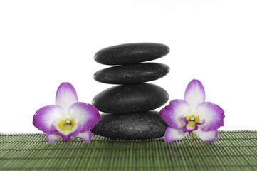 Stone tower with two pink orchid on green mat