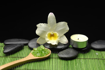 orchid, candle with zen stone and sea salt in spoon