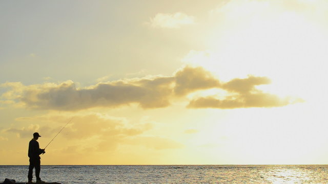 The Silhouette Of A Fisherman At Sunset In Hawaii