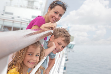 Mother with children stand on deck of passenger ship